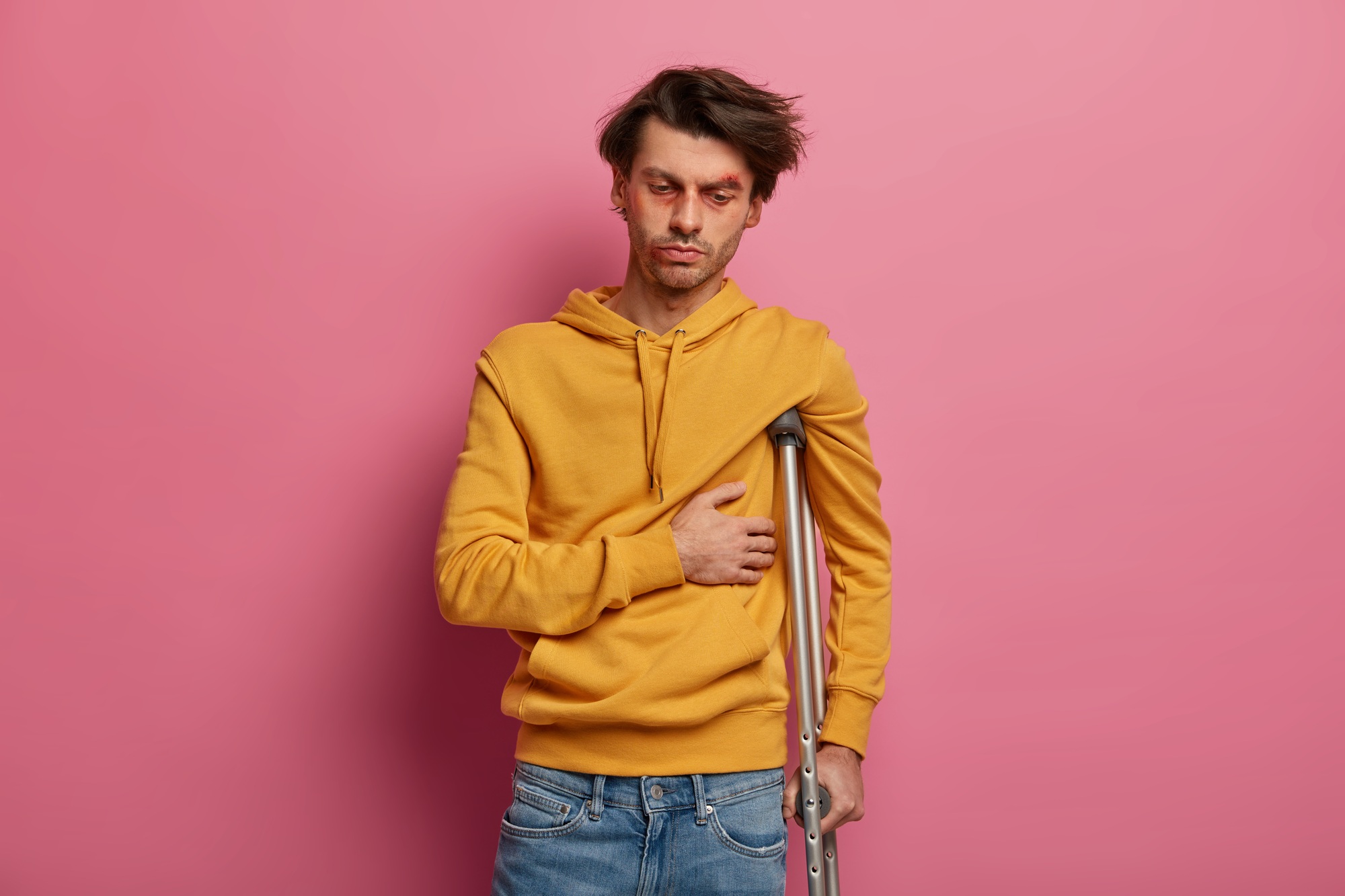 Distressed male feels pain in ribs, suffers from fracture after domestic accident, looks sadly down,